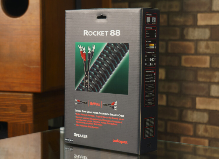Rocket 88 speaker cable packaging on a glass table with a brick wall behind it.