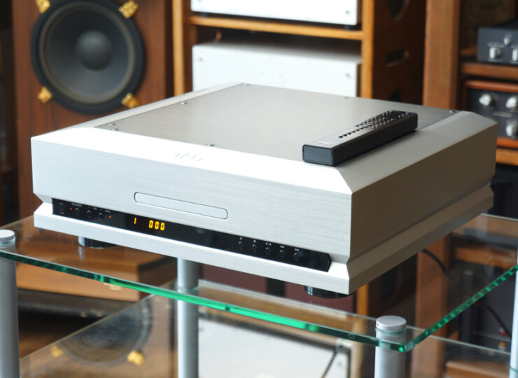 TAD TAD-D1000MK2 SILVER SACD/CDプレーヤー / 384kHz・32bit対応 / リモコンあり#R09883 Silver hi-fi CD player on a glass shelf with a remote on top; background shows a speaker and audio gear.