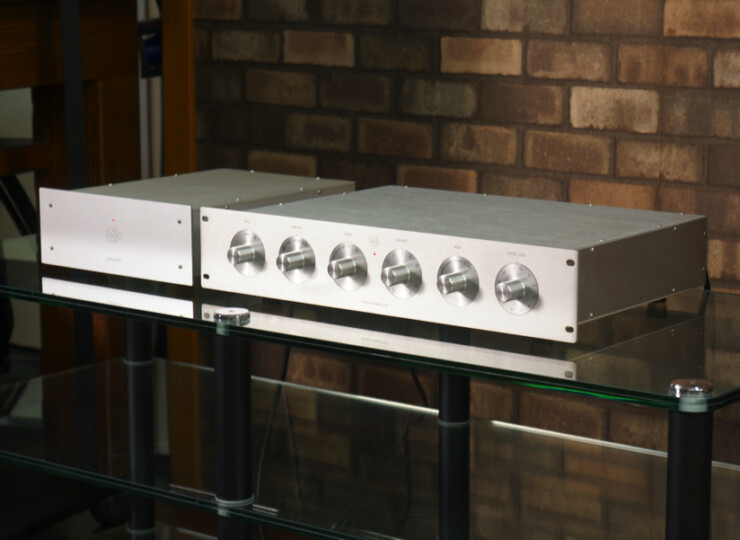 【美品】Cello ENCORE PRE チェロ プリアンプ 初期個体 / MMフォノ対応 動作良好 #R09974 Two silver audio amplifiers on a glass table against a brick wall, with six front knobs on the right unit.
