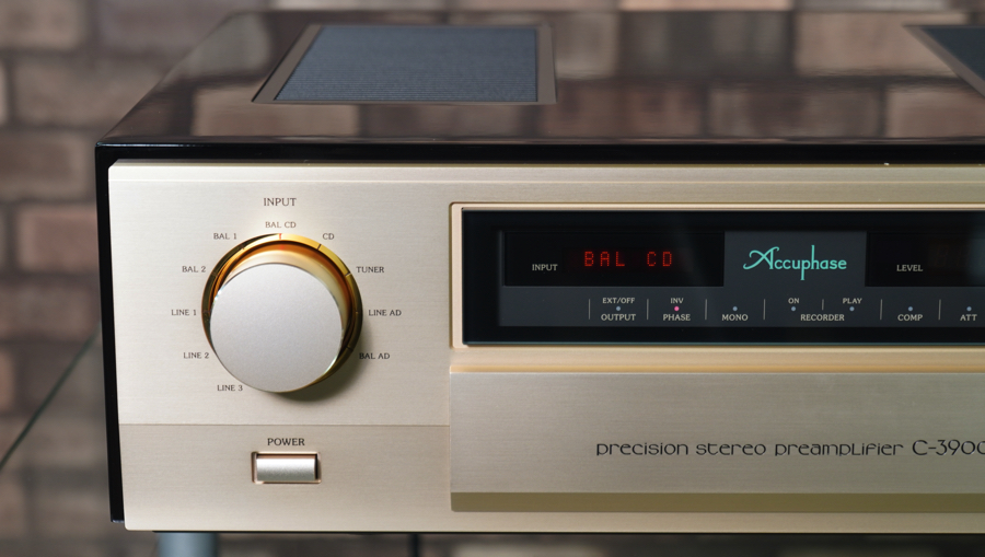 Close-up of an Accuphase precision stereo preamplifier model C-3900, showing a large brass knob, power switch, and display.
