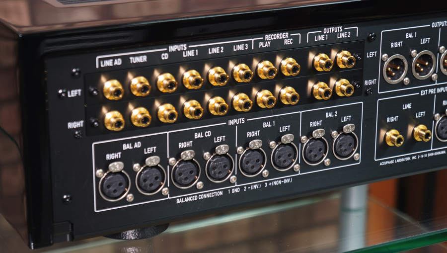 Back panel of professional audio equipment with many gold-plated connectors (RCA/BNC style) and XLR balanced inputs labeled for various channels (Line, Tuner, CD, Bal Left/Right).